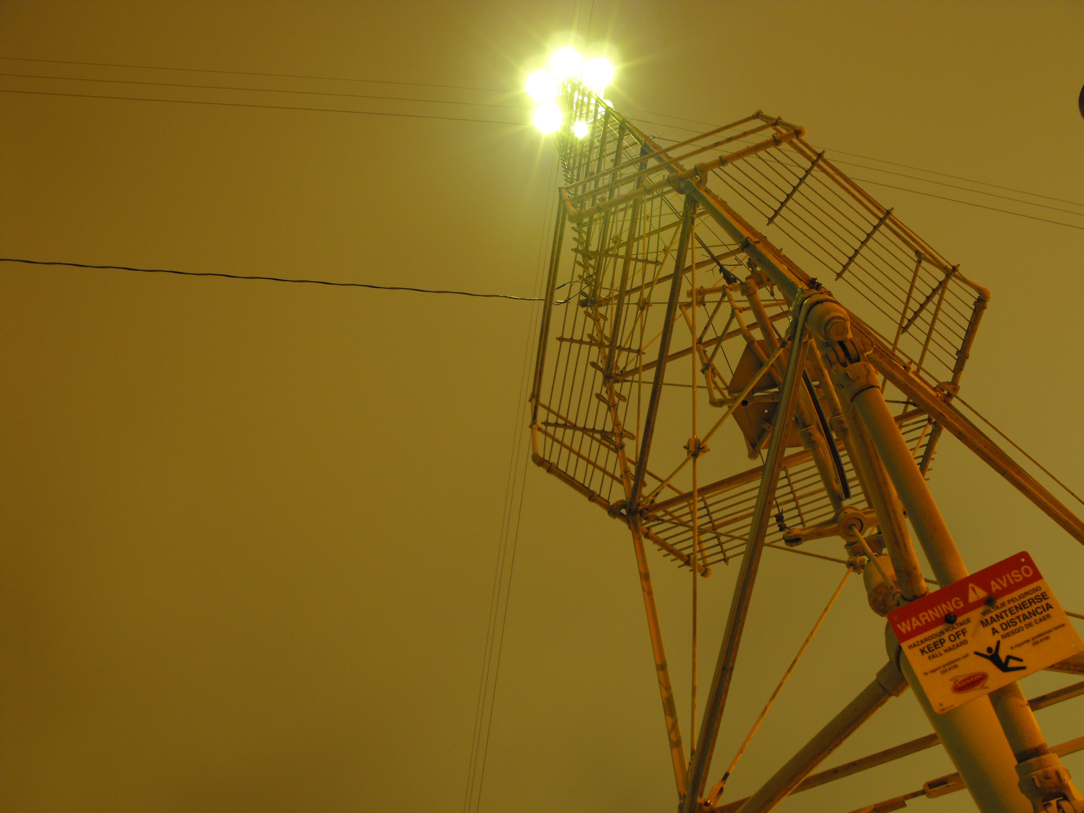 One of Austin's historic moonlight towers illuminated at night, a 165-foot iron structure still operating since 1894